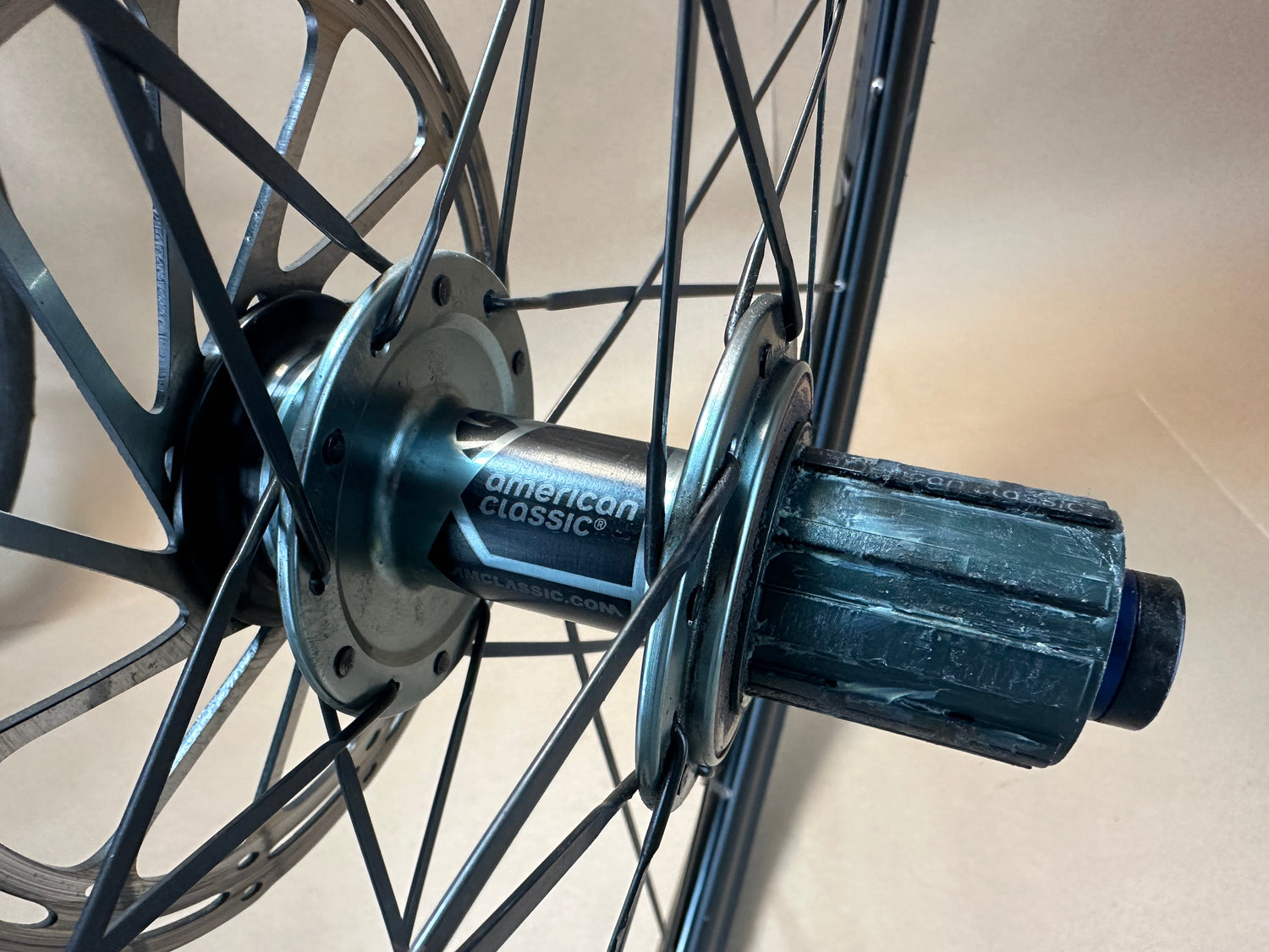 Close-up of a bicycle hub with 'American Classic' branding on a neutral background