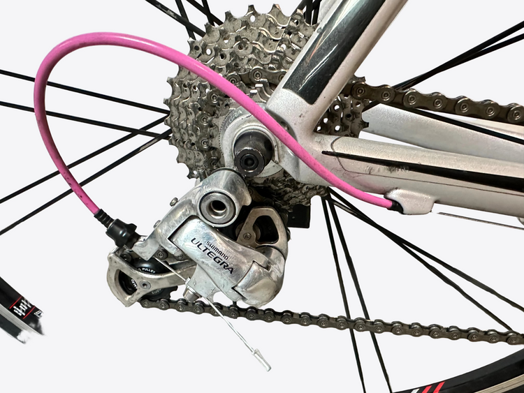 Close-up of a bicycle's gear system with a pink cable.