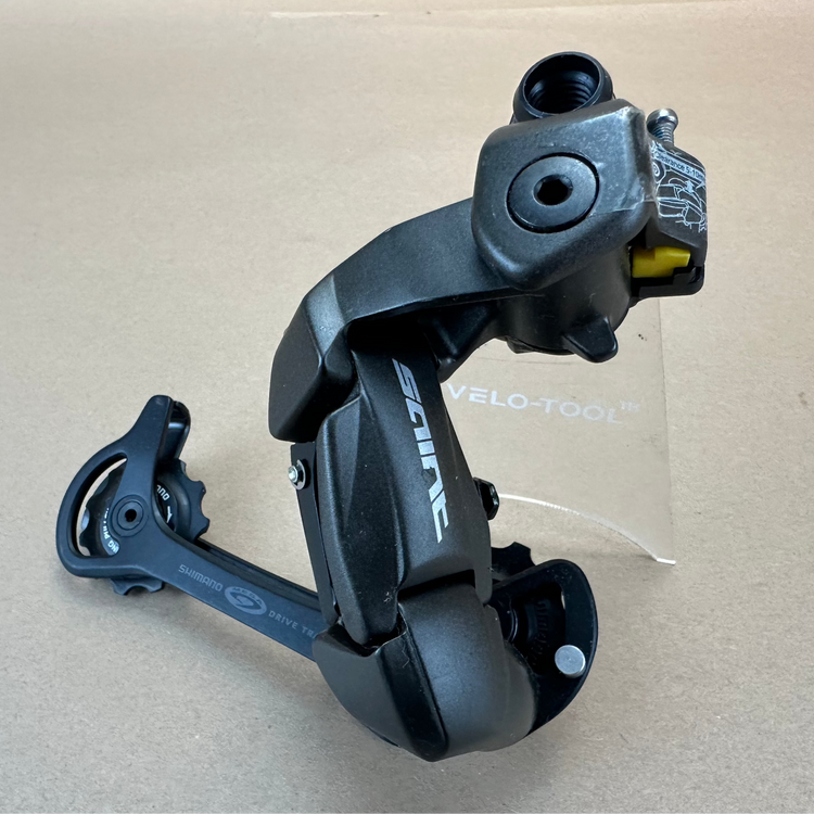 Black bicycle derailleur on a beige background