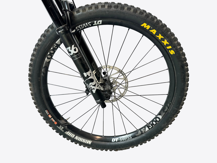 Close-up of a bicycle wheel with 'Maxxis' and 'DT Swiss' branding on a white background