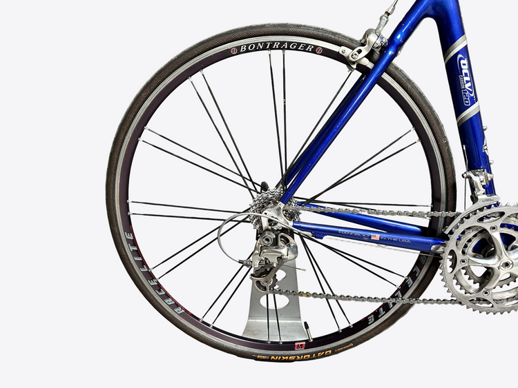 Blue bicycle with Bontrager components against a gray brick wall.