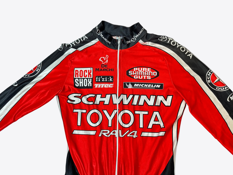 Red cycling jersey with various brand logos on a light blue background
