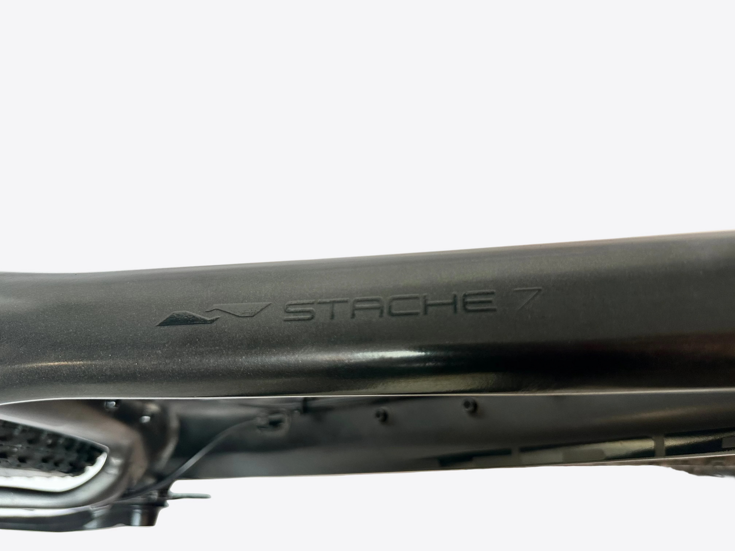 Close-up of a bicycle frame with 'Stache 7' branding on a blurred background