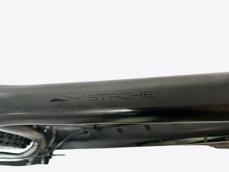 Close-up of a bicycle frame with 'Stache 7' branding on a blurred background