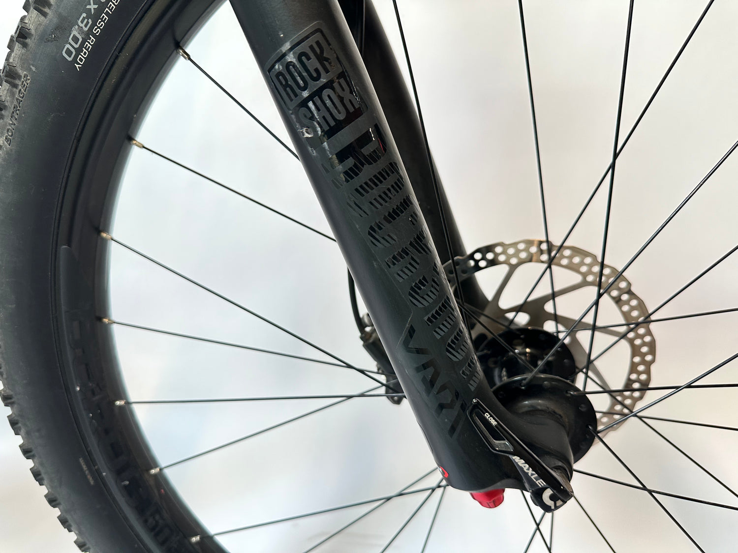 Close-up of a bicycle wheel with a Rock Shox suspension fork on a white background