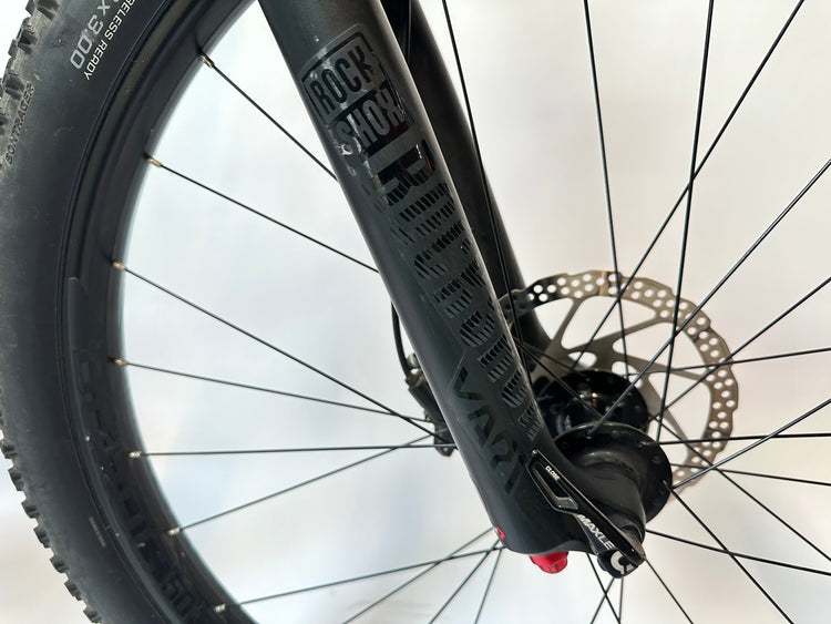 Close-up of a bicycle wheel with a Rock Shox suspension fork on a white background