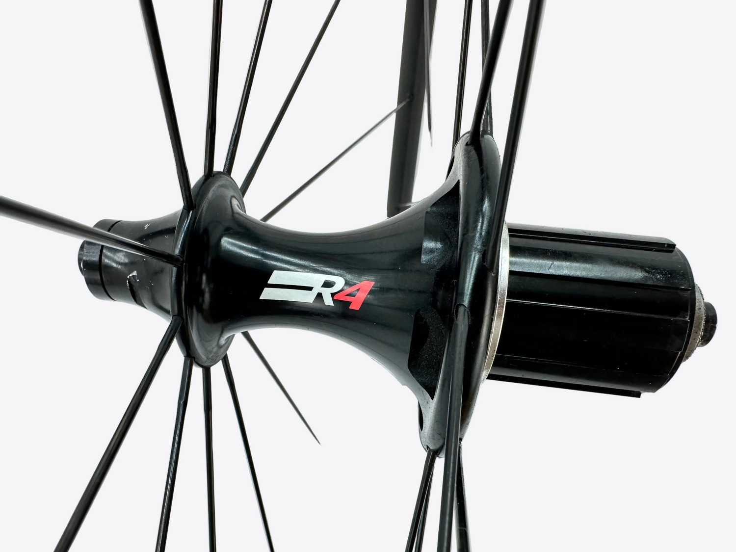 Close-up of a bicycle hub with 'R4' branding on a white background