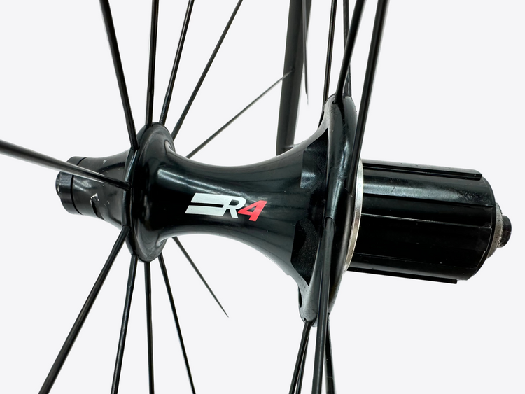 Close-up of a bicycle hub with 'R4' branding on a white background