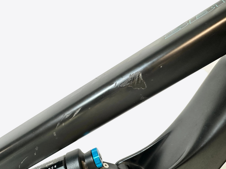 Close-up of a bicycle frame with visible scratches on a white background