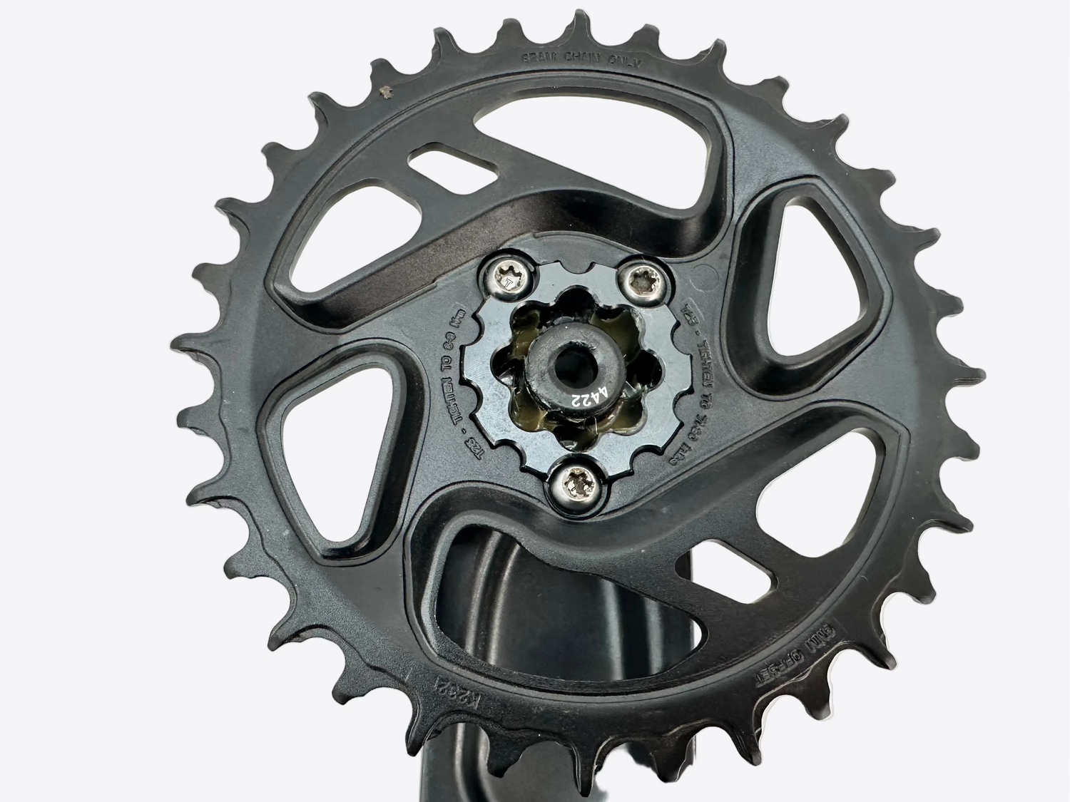 Close-up of a black bicycle chainring on a white background