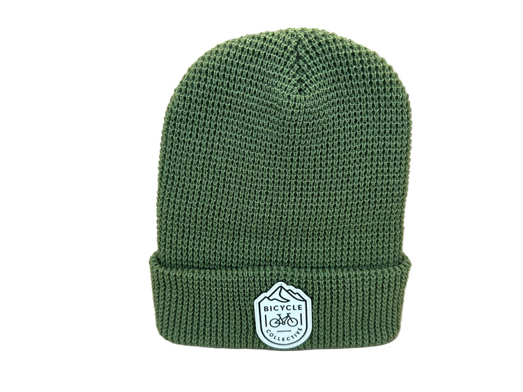 Green knit beanie with a logo on a white background
