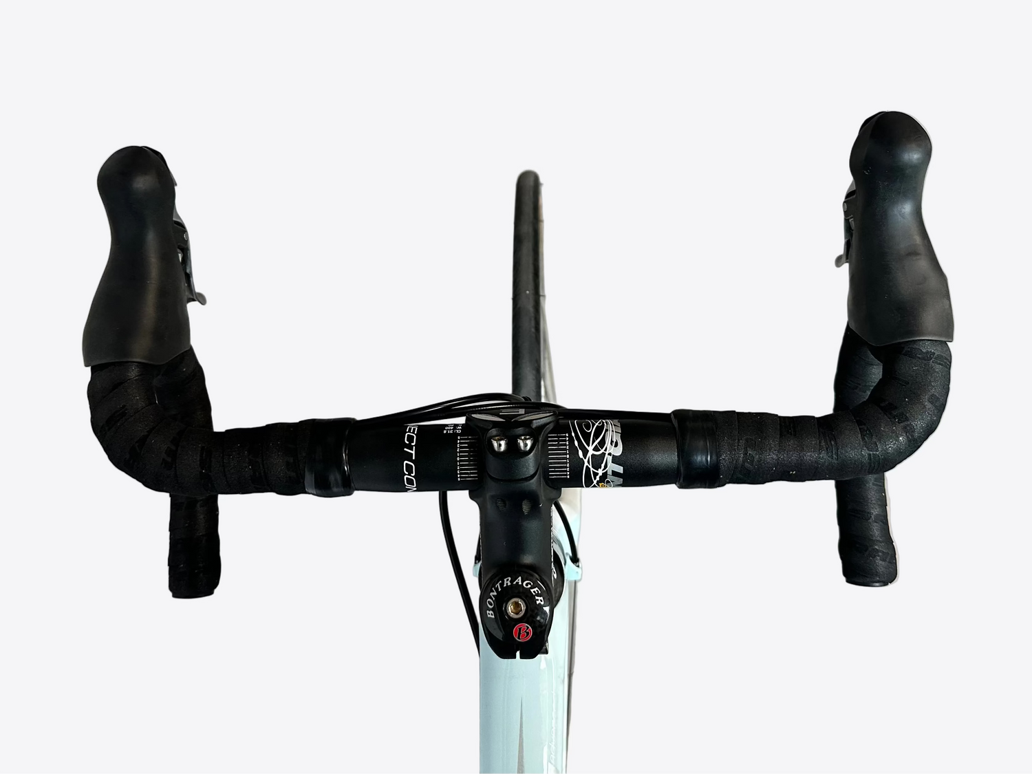 Bicycle handlebar with black grips and white frame on a concrete floor.
