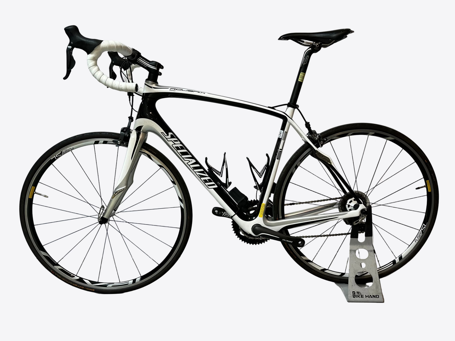 White bicycle with black components on a stand against a white background