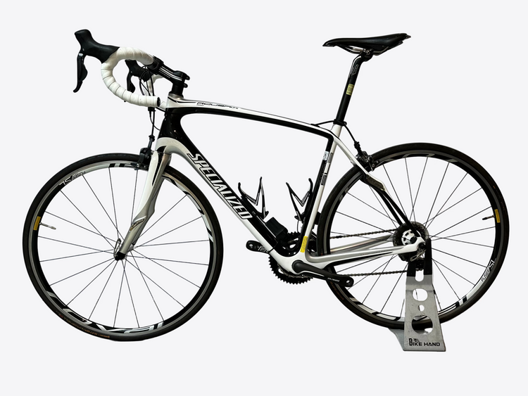 White bicycle with black components on a stand against a white background