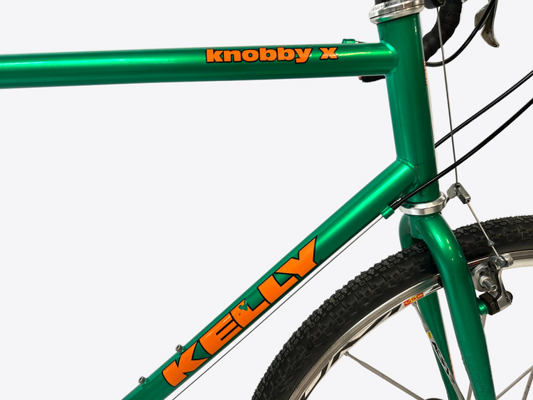 Green bicycle frame with 'knobby x' and 'kelly' branding on a white background