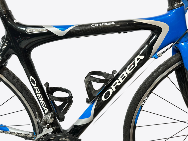 Close-up of a blue and black Orbea bicycle frame with water bottle holders.