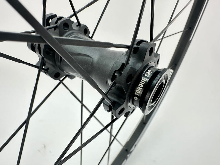 Close-up of a bicycle hub with 'Torque cap' branding on a white background