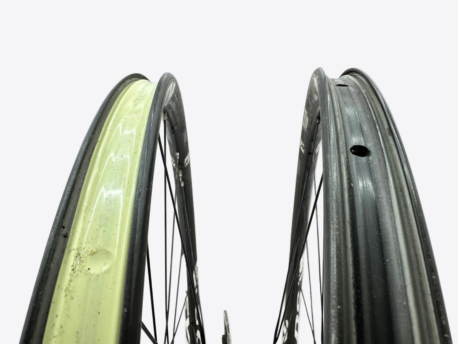 Two bicycle wheels with different rim designs on a light gray background