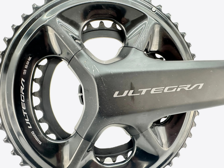 Close-up of a bicycle crankset with 'Ultegra' branding on a white background