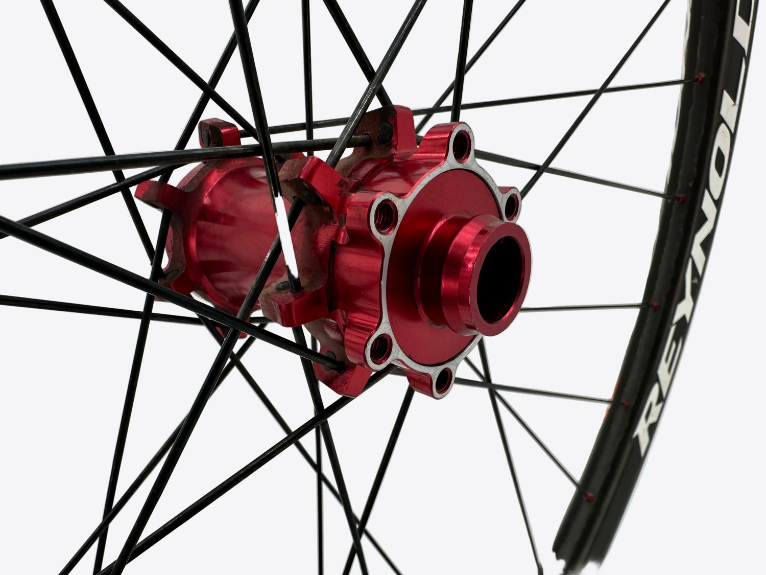Close-up of a red bicycle hub with black spokes on a white background