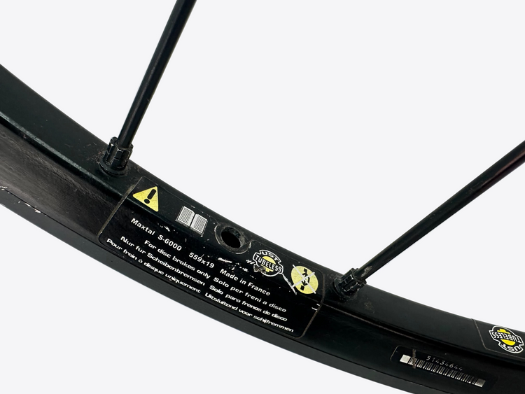 Close-up of a bicycle wheel with branding and specifications on a white background
