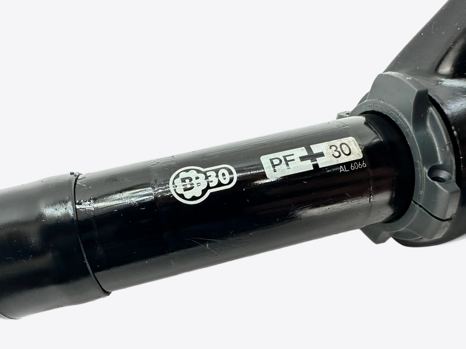 Close-up of a bicycle fork with 'BB30' and 'PF+30' labels on a white background