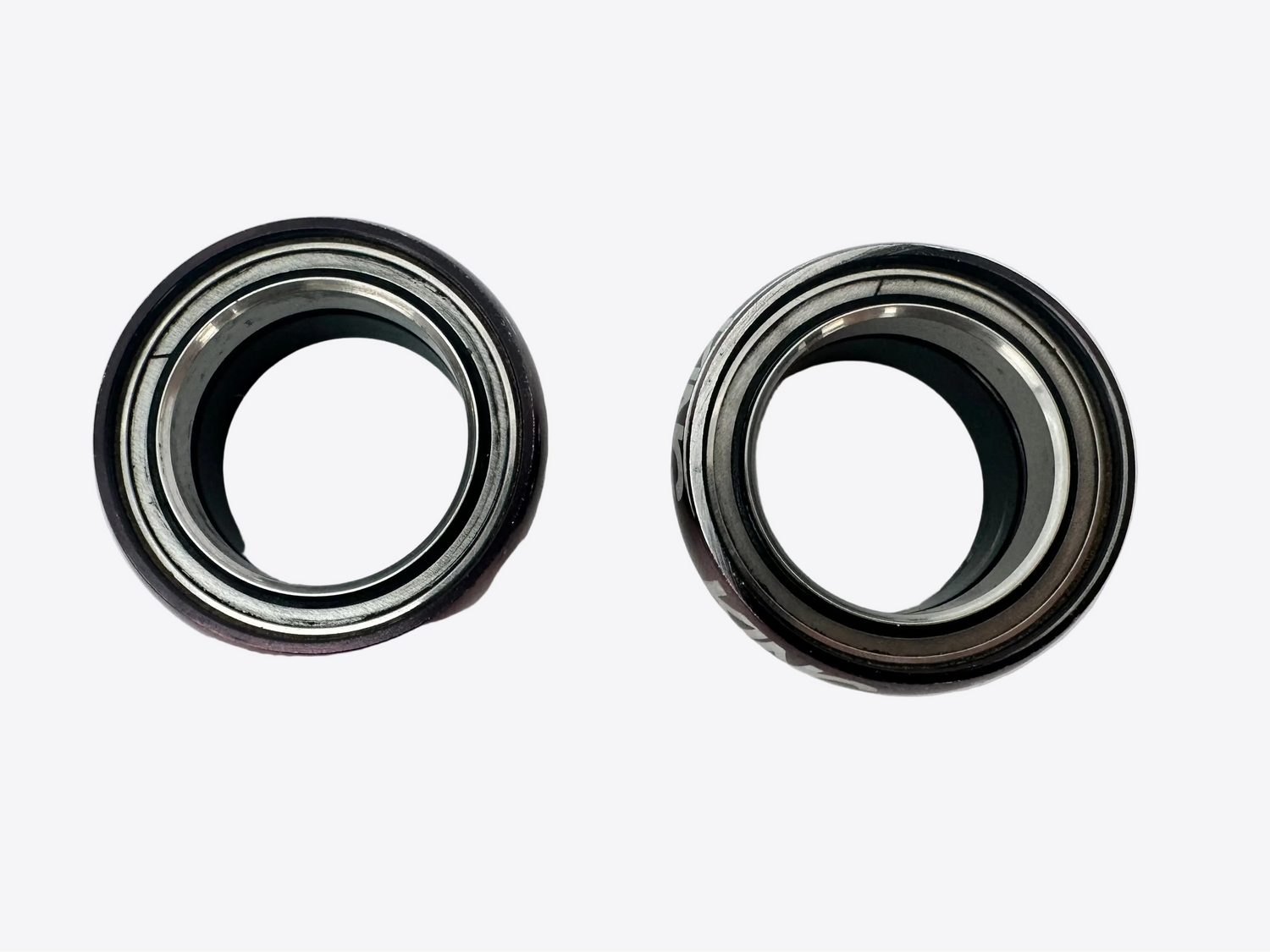 Two metal bearings on a white surface