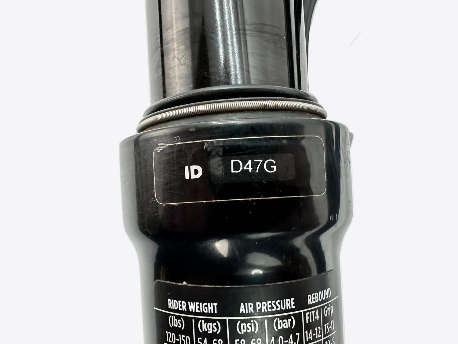 Close-up of a bicycle suspension fork with branding and specifications on a white background