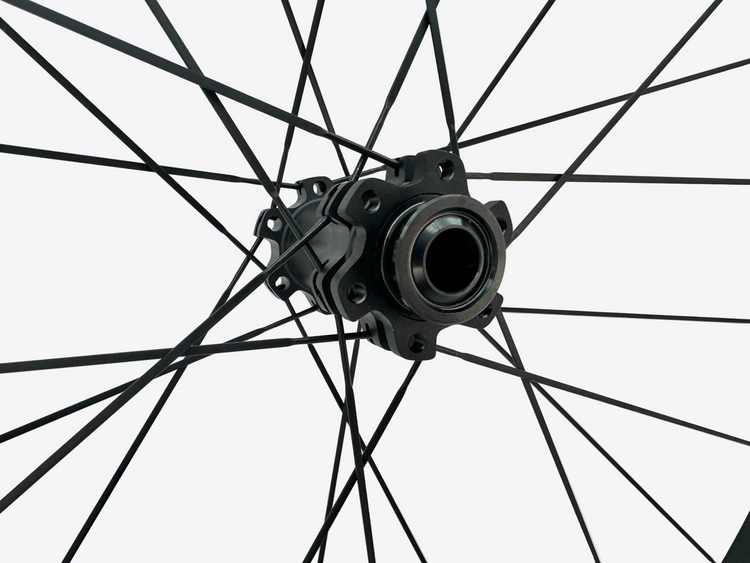 Close-up of a bicycle wheel hub with spokes against a light gray background