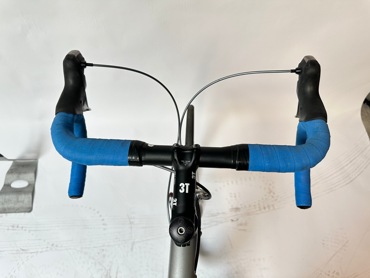 Bicycle handlebar with blue grips on a white background