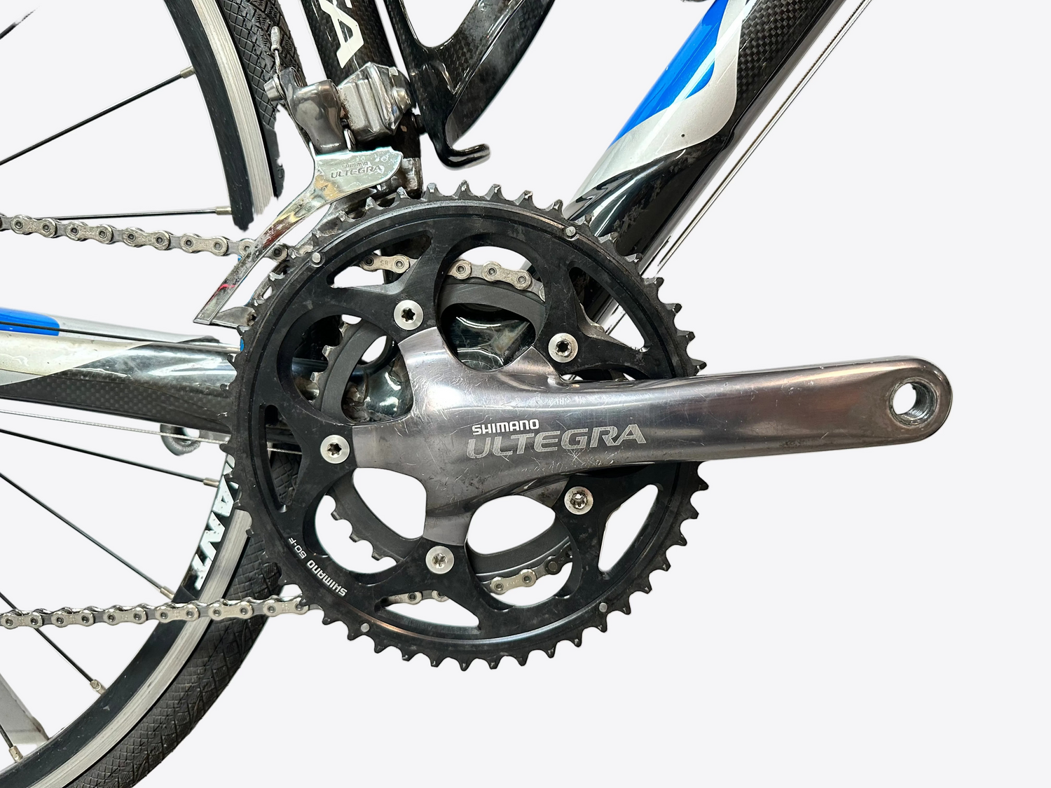 Close-up of a bicycle crankset with Shimano Deore brand name on a blurred background