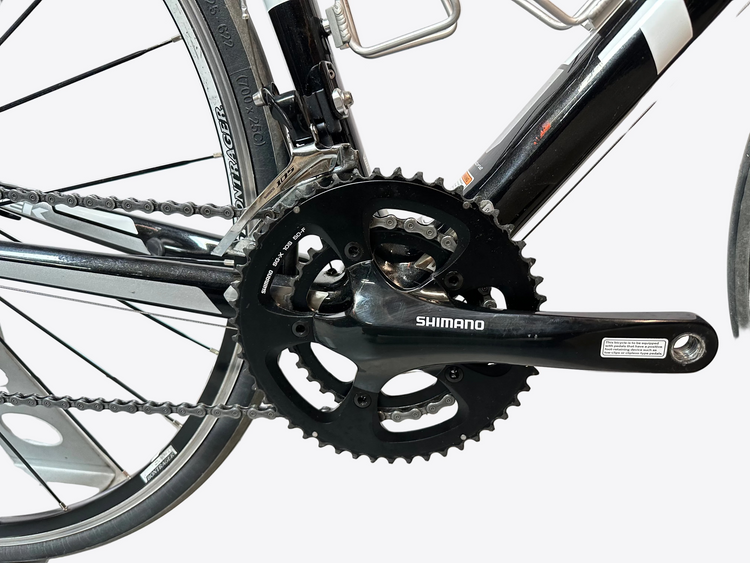 Close-up of a bicycle chain and gear system with Shimano branding.
