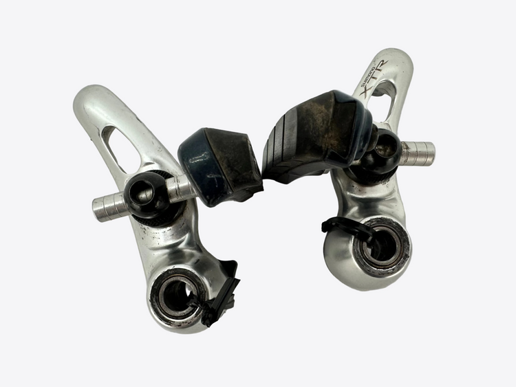 Two metal brake calipers on a white background
