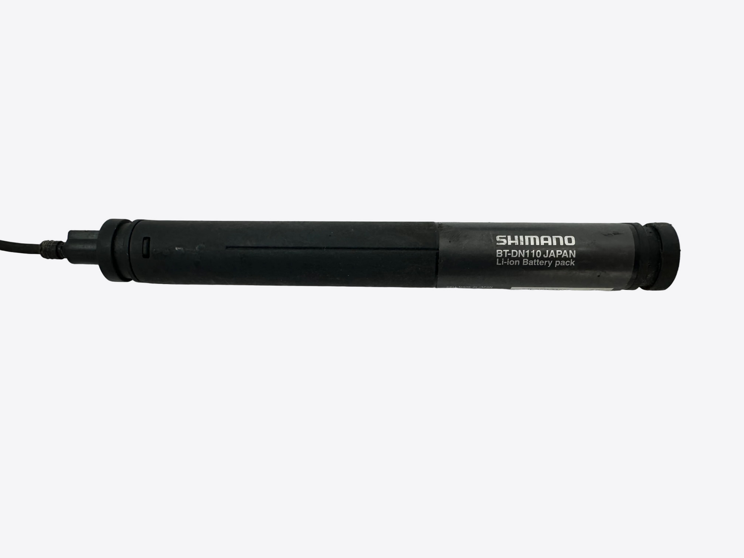 Black Shimano battery pack on a white surface