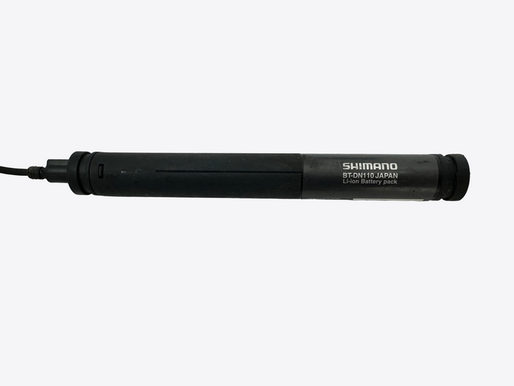 Black Shimano battery pack on a white surface