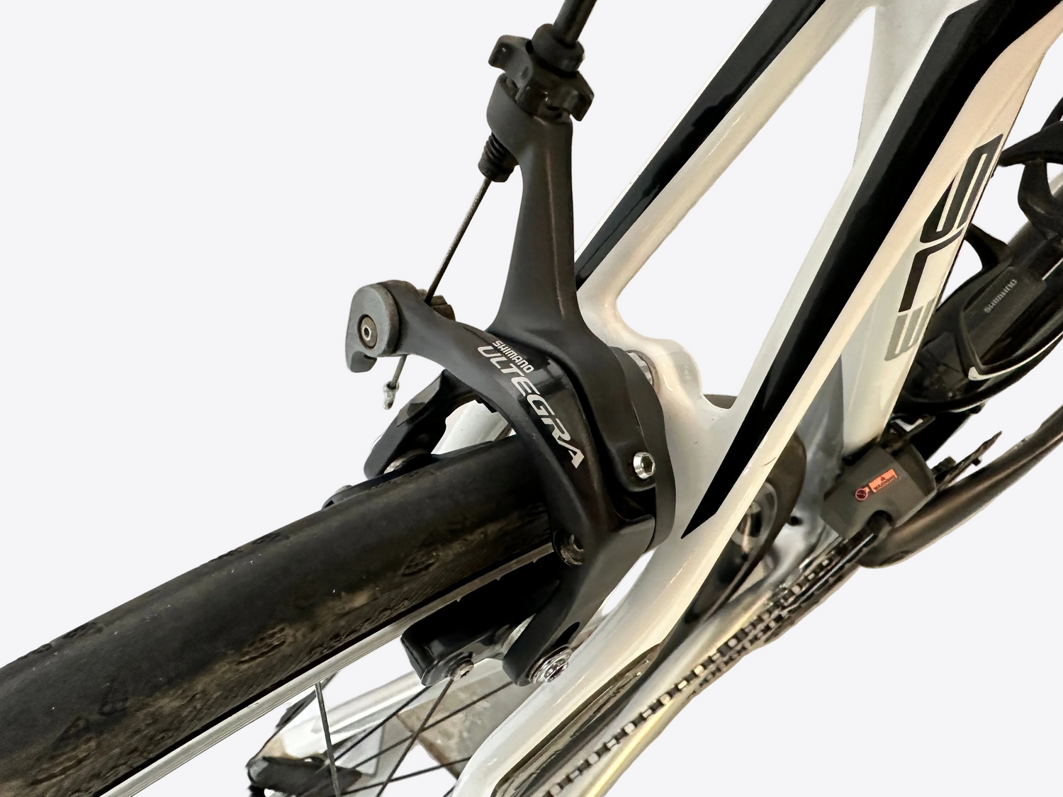 Close-up of a bicycle's chain mechanism with 'Shimano' branding on a white background.