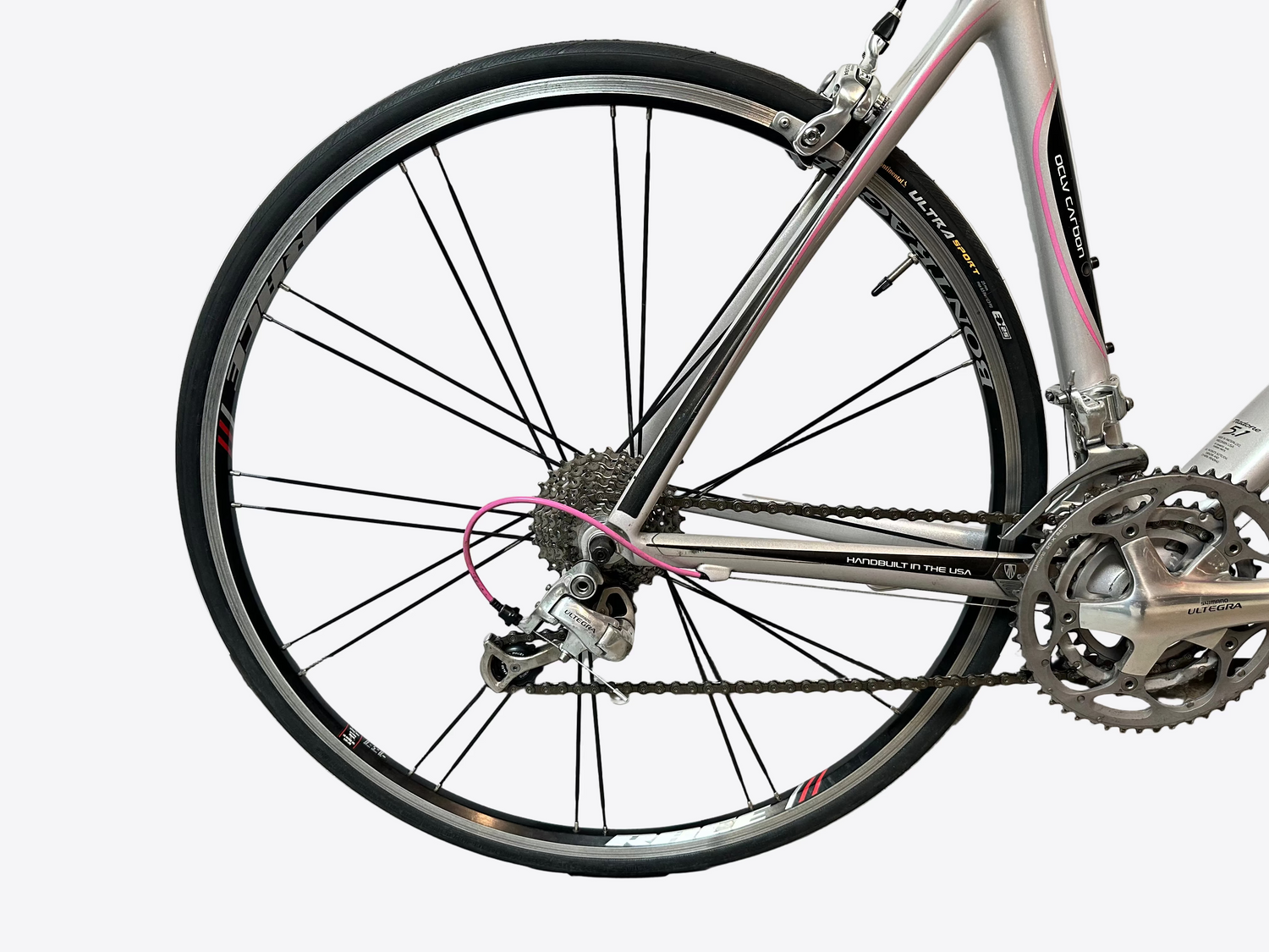Close-up of a bicycle wheel and chain on a white background