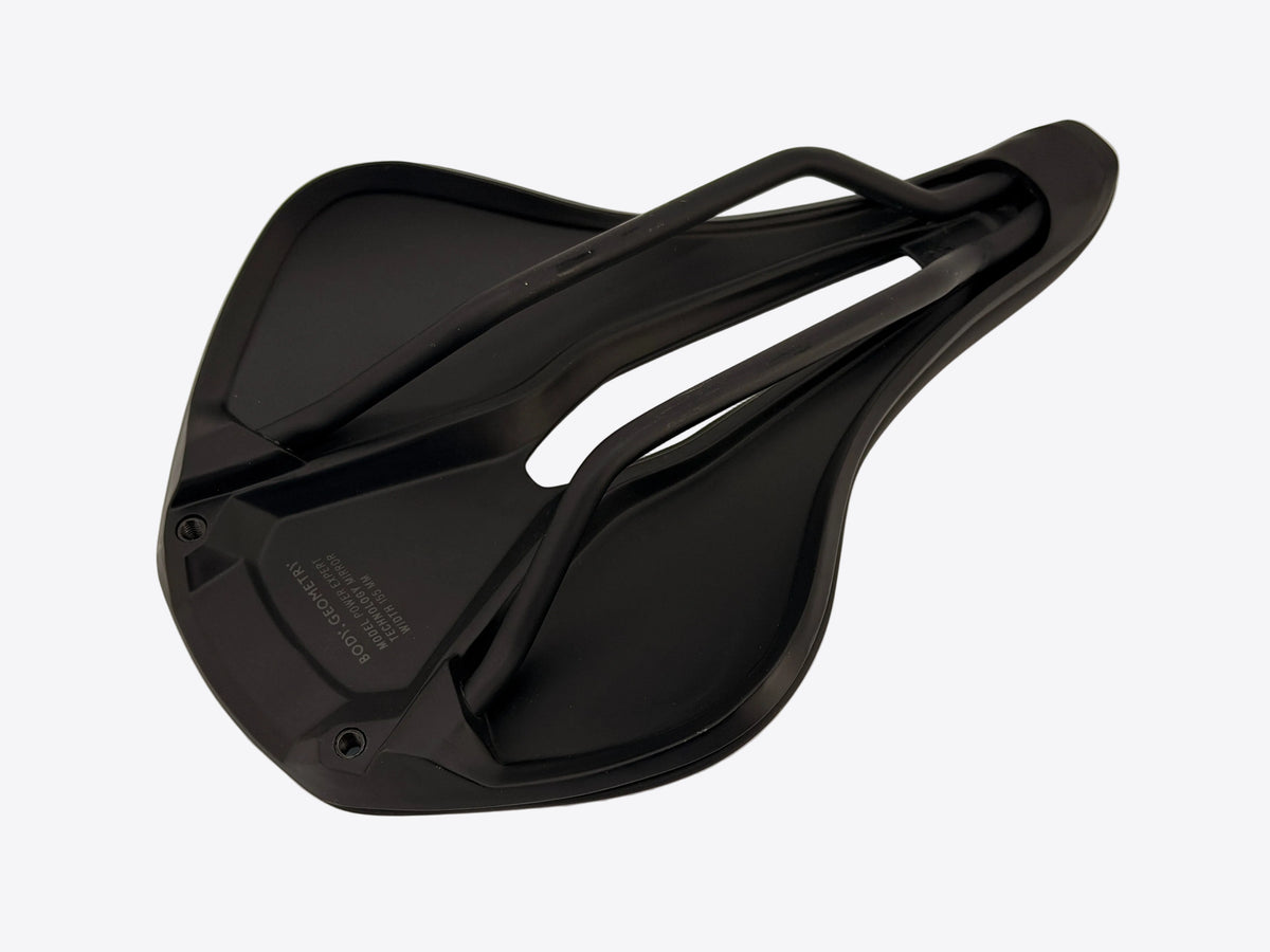 A black bicycle saddle shown from a top-down angle on a plain off-white background.