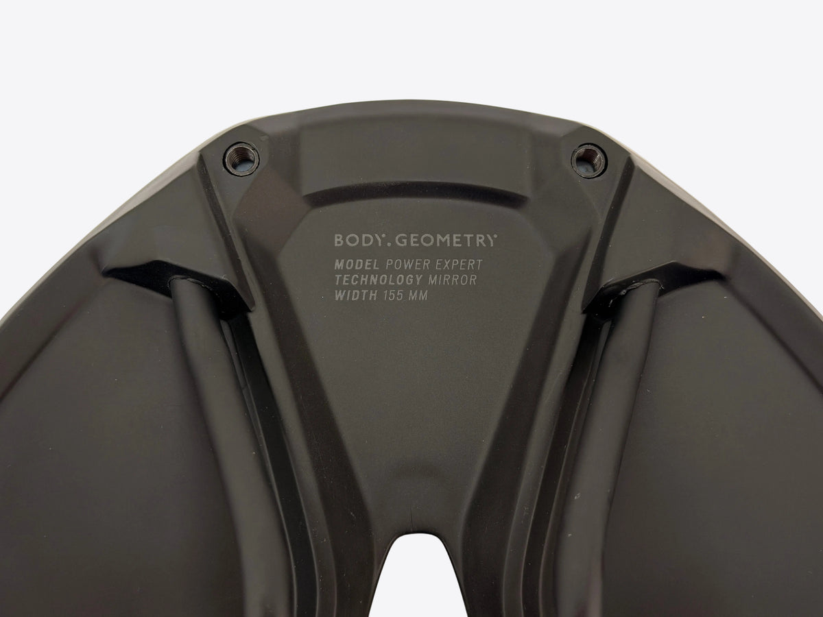 Close-up of the black textured plastic rear cover of a bicycle mirror, featuring the white printed text 'BODY, GEOMETRY' and model specifications.